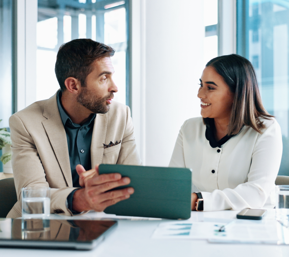 Two colleagues discussing work in office.
